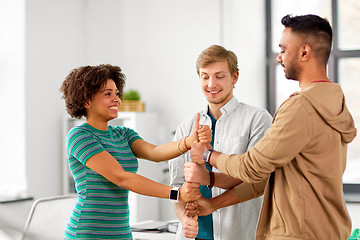 Image showing happy creative team making high five at office