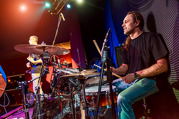 Image showing Drummer playing on drum set on stage.