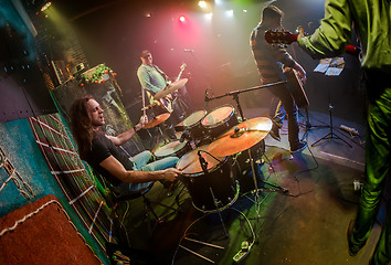 Image showing Drummer playing on drum set on stage.