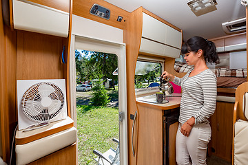 Image showing Woman cooking in camper, motorhome interior