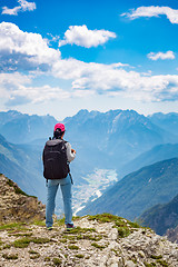 Image showing Hiker woman standing up achieving the top Dolomites Alps.