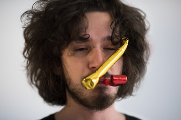 Image showing Portrait of a man in party hat blowing in whistle