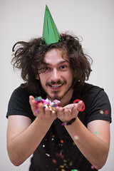 Image showing man blowing confetti in the air