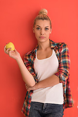 Image showing woman over color background plays with apple