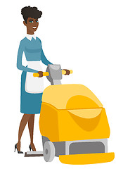 Image showing African worker cleaning store floor with machine.