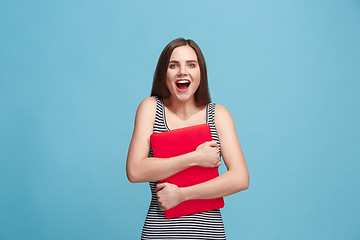 Image showing Businesswoman hugging laptop on blue studio