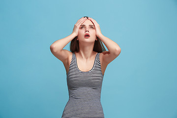 Image showing Woman having headache. Isolated over blue background.