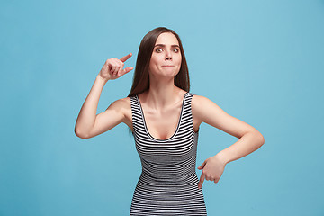 Image showing Portrait of an argue woman looking at camera isolated on a blue background