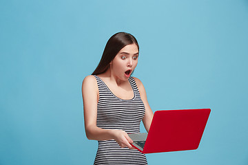 Image showing Businesswoman with laptop on blue studio