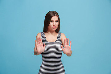 Image showing Let me think. Doubtful pensive woman with thoughtful expression making choice against blue background