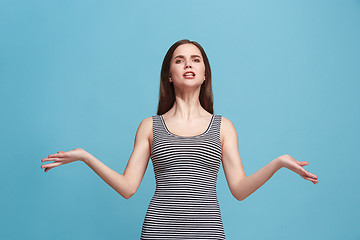 Image showing Portrait of an angry woman looking at camera isolated on a blue background