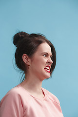 Image showing Portrait of an angry woman looking away isolated on a blue background