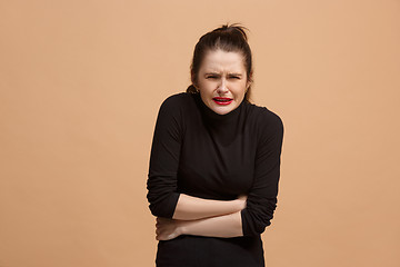 Image showing Young woman overwhelmed with a pain in the stomach .