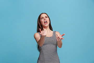 Image showing Portrait of an angry woman looking at camera isolated on a blue background