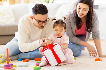 Image showing baby girl with birthday gift and parents at home 