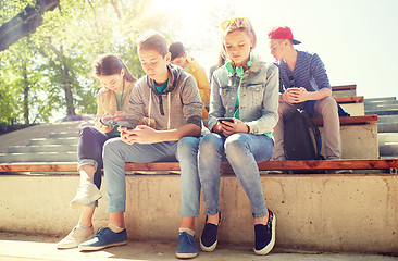 Image showing group of teenage friends with smartphones outdoors