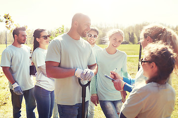 Image showing group of volunteers with tree seedlings in park