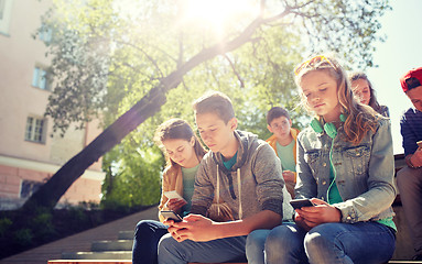 Image showing group of teenage friends with smartphones outdoors