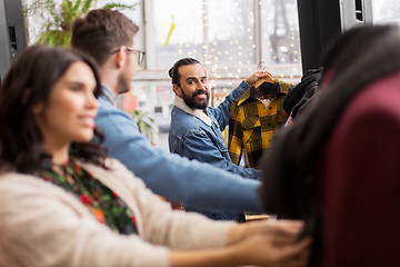 Image showing friends choosing clothes at vintage clothing store