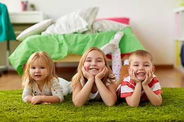 Image showing happy little kids lying on floor or carpet