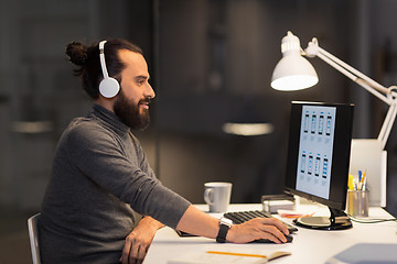 Image showing creative man in headphones working at night office