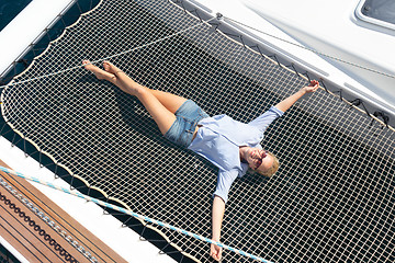 Image showing Woman relaxing on a luxury catamaran sailing boat.