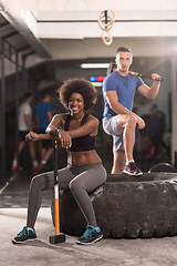 Image showing multiethnic couple after workout with hammer