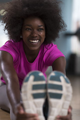 Image showing woman in a gym stretching and warming up before workout