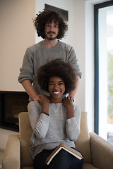 Image showing multiethnic couple hugging in front of fireplace