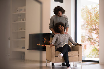 Image showing multiethnic couple hugging in front of fireplace