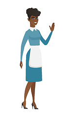 Image showing Young african cleaner waving her hand.