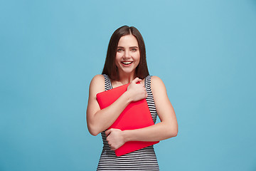 Image showing Businesswoman hugging laptop on blue studio