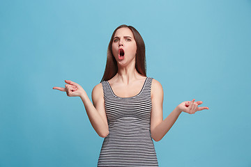 Image showing Portrait of an argue woman looking at camera isolated on a blue background