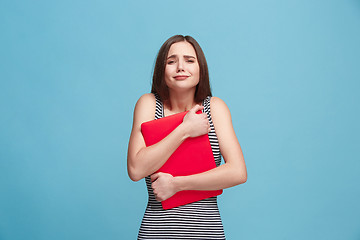 Image showing Businesswoman hugging laptop on blue studio