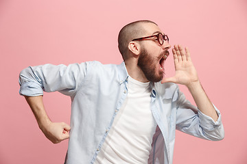 Image showing Isolated on pink young casual man shouting at studio