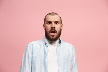 Image showing The young attractive man looking suprised isolated on pink