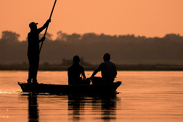 Image showing Men in a boat on a river silhouette