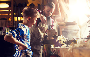 Image showing father and son with drill working at workshop