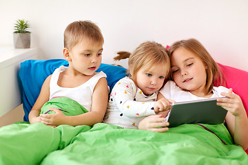 Image showing little kids with tablet pc in bed at home