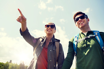 Image showing happy couple with backpacks hiking outdoors