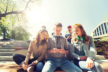 Image showing happy teenage friends with smartphones outdoors