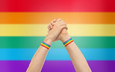 Image showing hands with gay pride wristbands in winning gesture