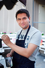 Image showing Barista making coffee and looking at camera