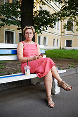 Image showing Adult woman using smartphone on bench