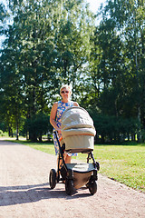 Image showing Woman walking with baby stroller