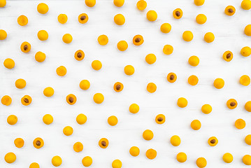 Image showing Whole and cut wild yellow plums on white wooden background