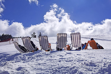 Image showing Skiers sunbathing on the ski slope with blue sky background