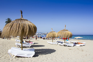 Image showing Sunbeds and umbrellas on a beautiful beach in Ibiza