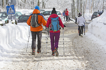 Image showing Young couple hiking outside on the snow in winter mountains