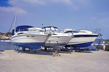 Image showing Luxury motor yachts at shipyard waiting for maintenance and repa